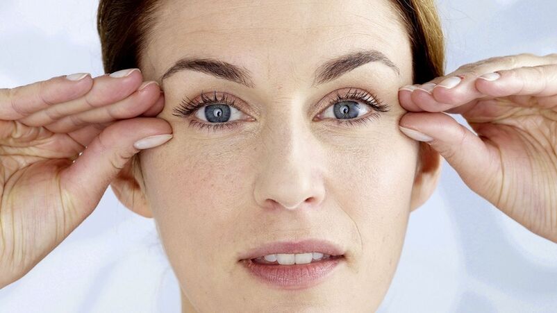 Une femme tient ses mains près des yeux